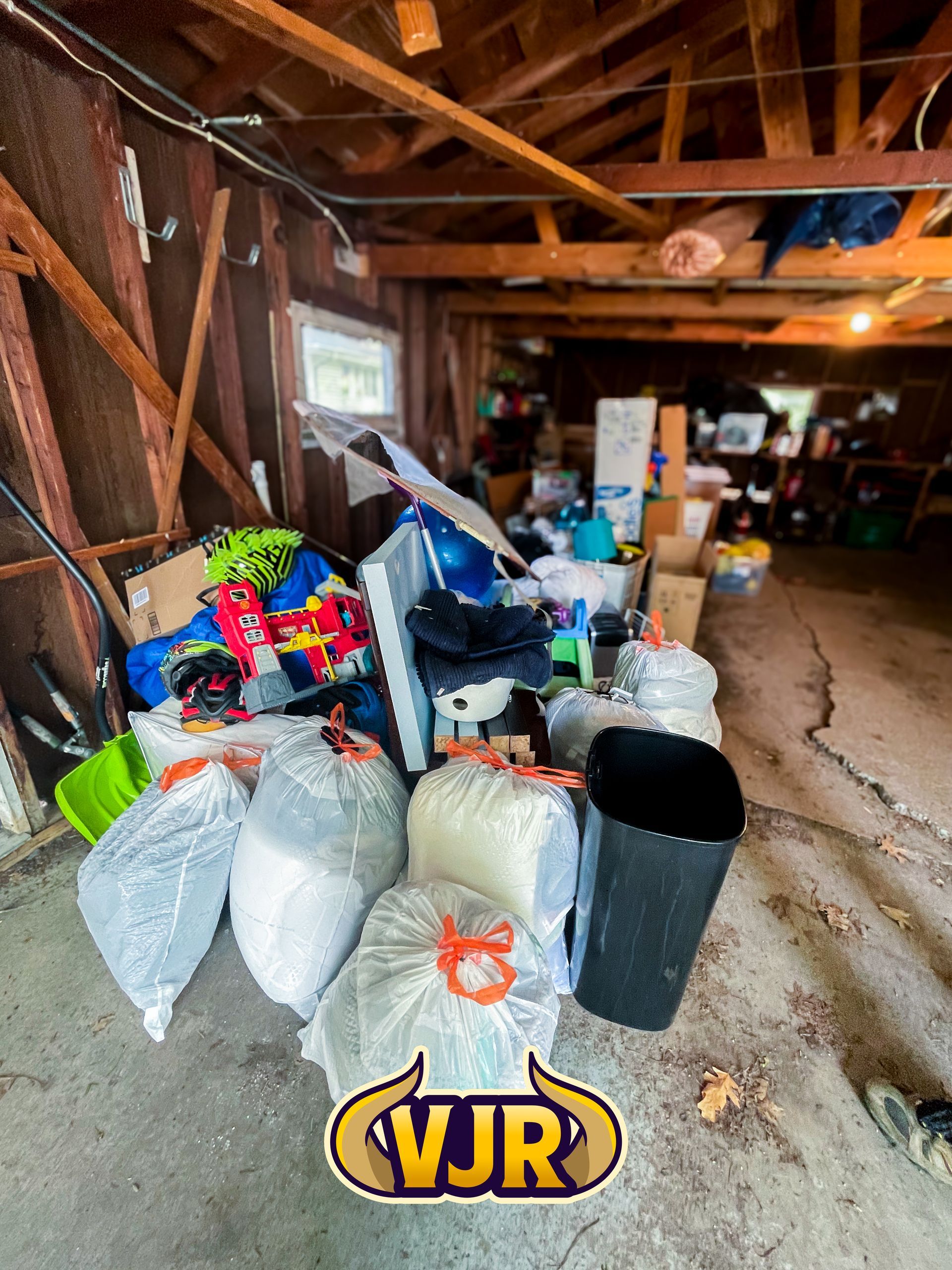 A garage filled with lots of trash bags and boxes.