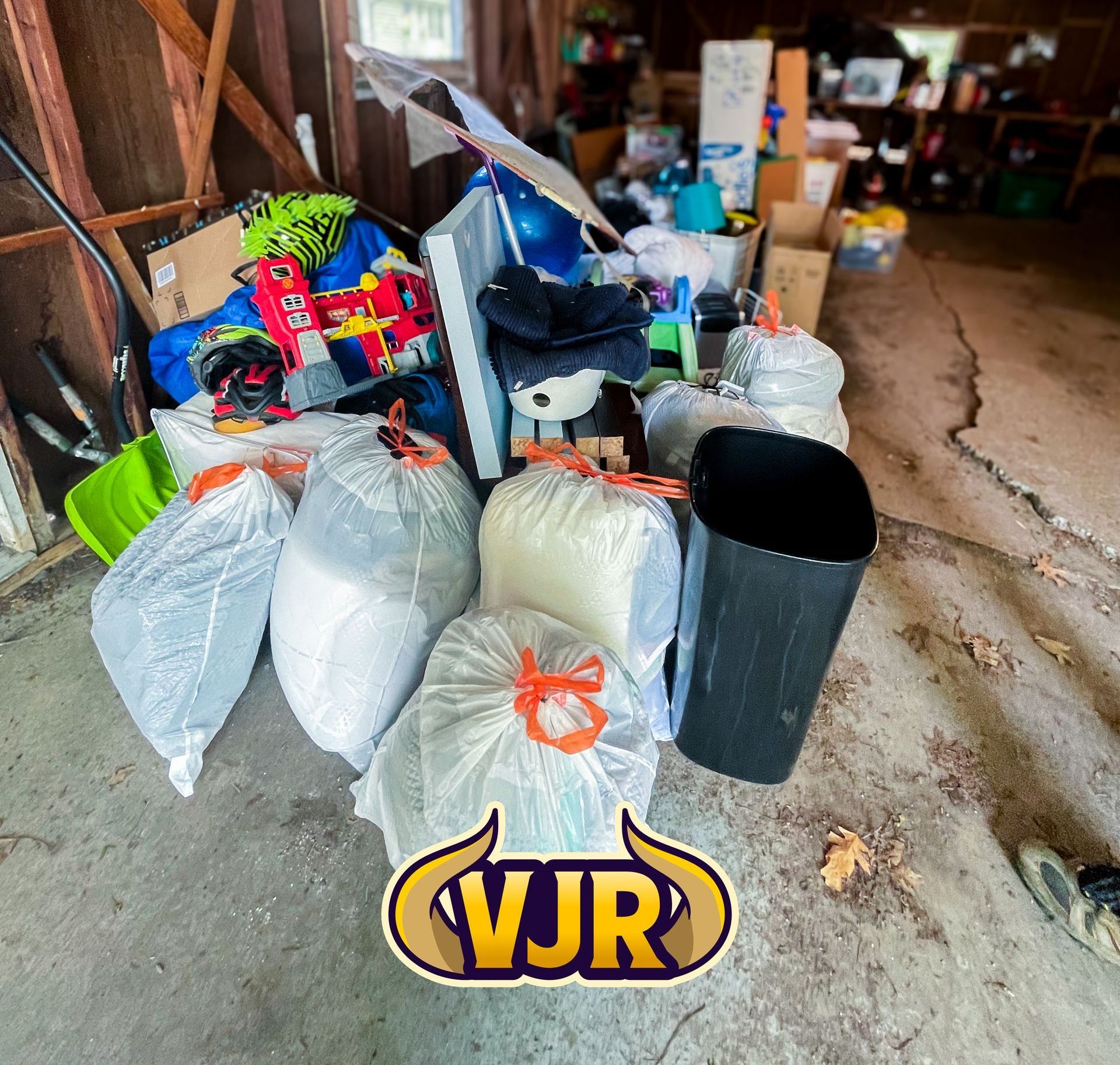 A pile of garbage in a garage with a vjr logo