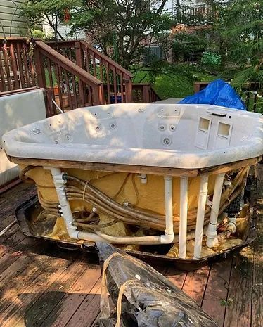 A hot tub is sitting on top of a wooden deck.