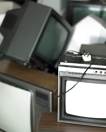 A bunch of old televisions are stacked on top of each other