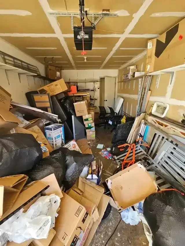 A garage filled with lots of boxes and trash bags