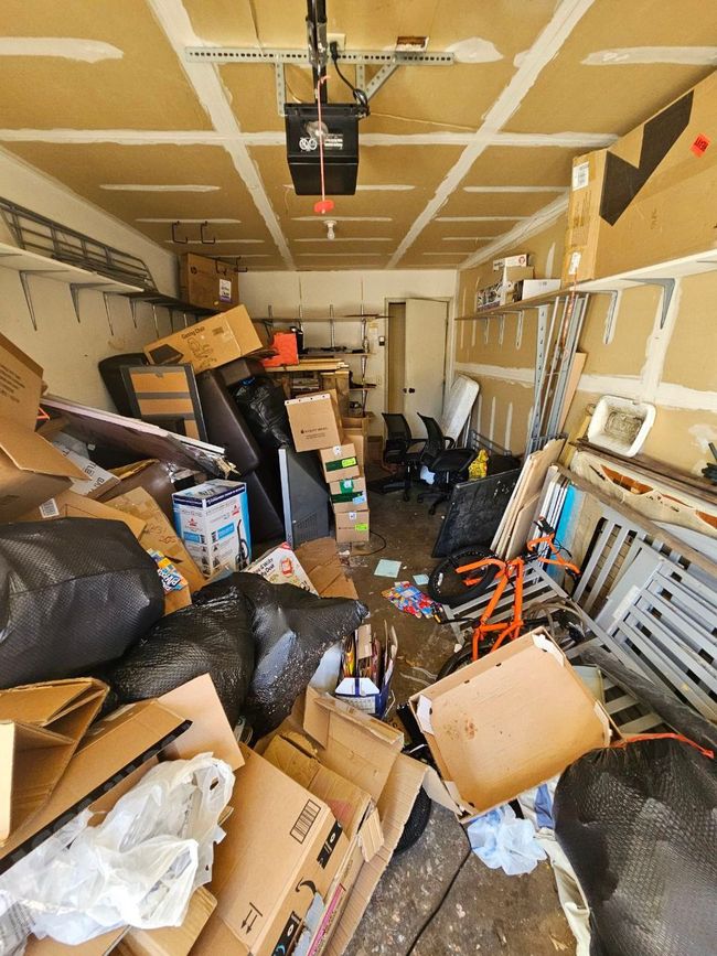 A garage filled with lots of boxes and trash bags