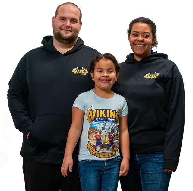 A man and woman standing next to a little girl wearing a viking shirt