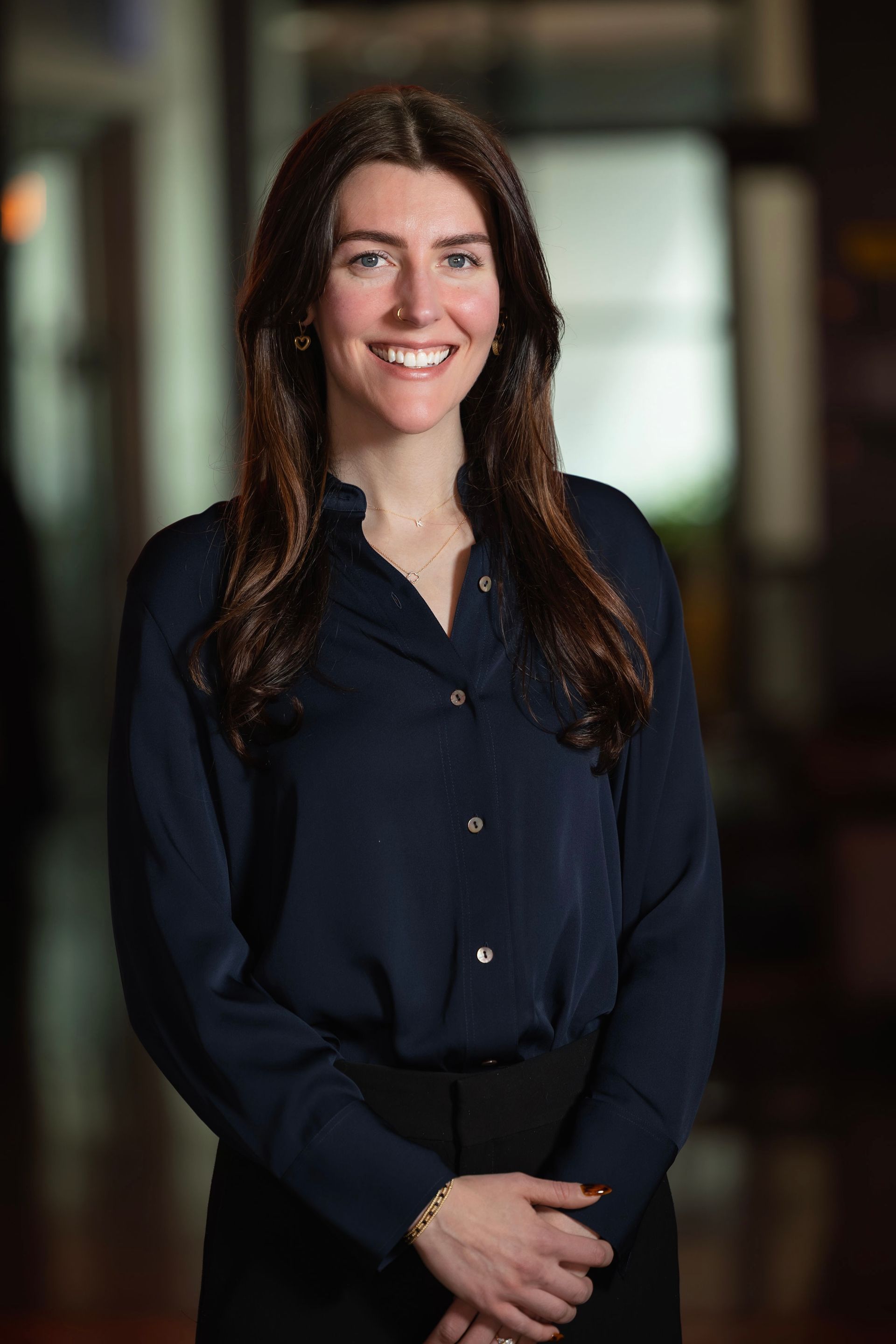 The woman is wearing a blue shirt and smiling for the camera.