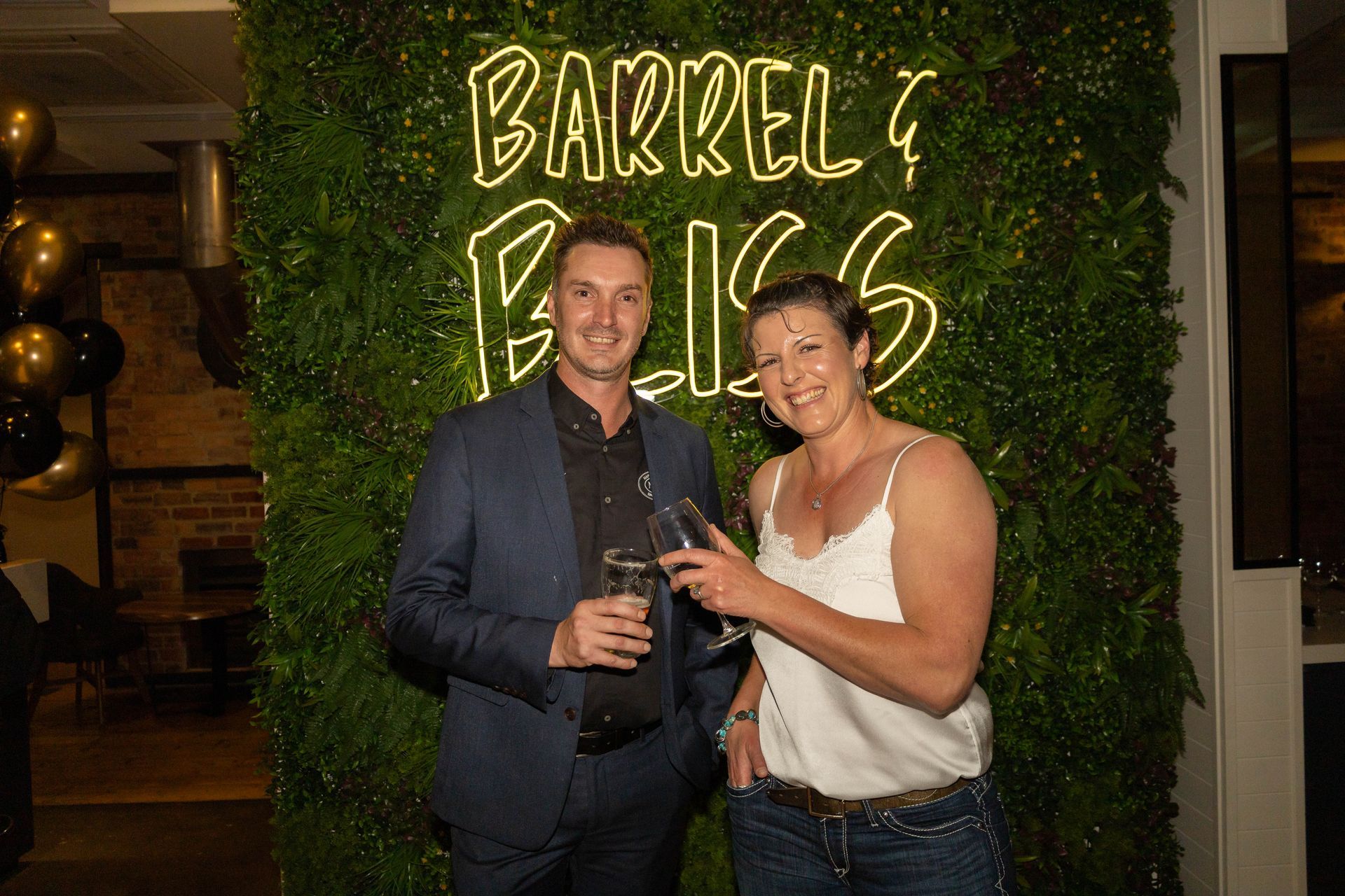 Man and woman toast, in front of 