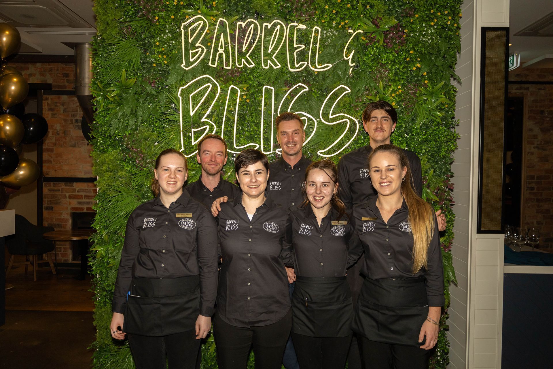 Group of restaurant staff posing in front of 