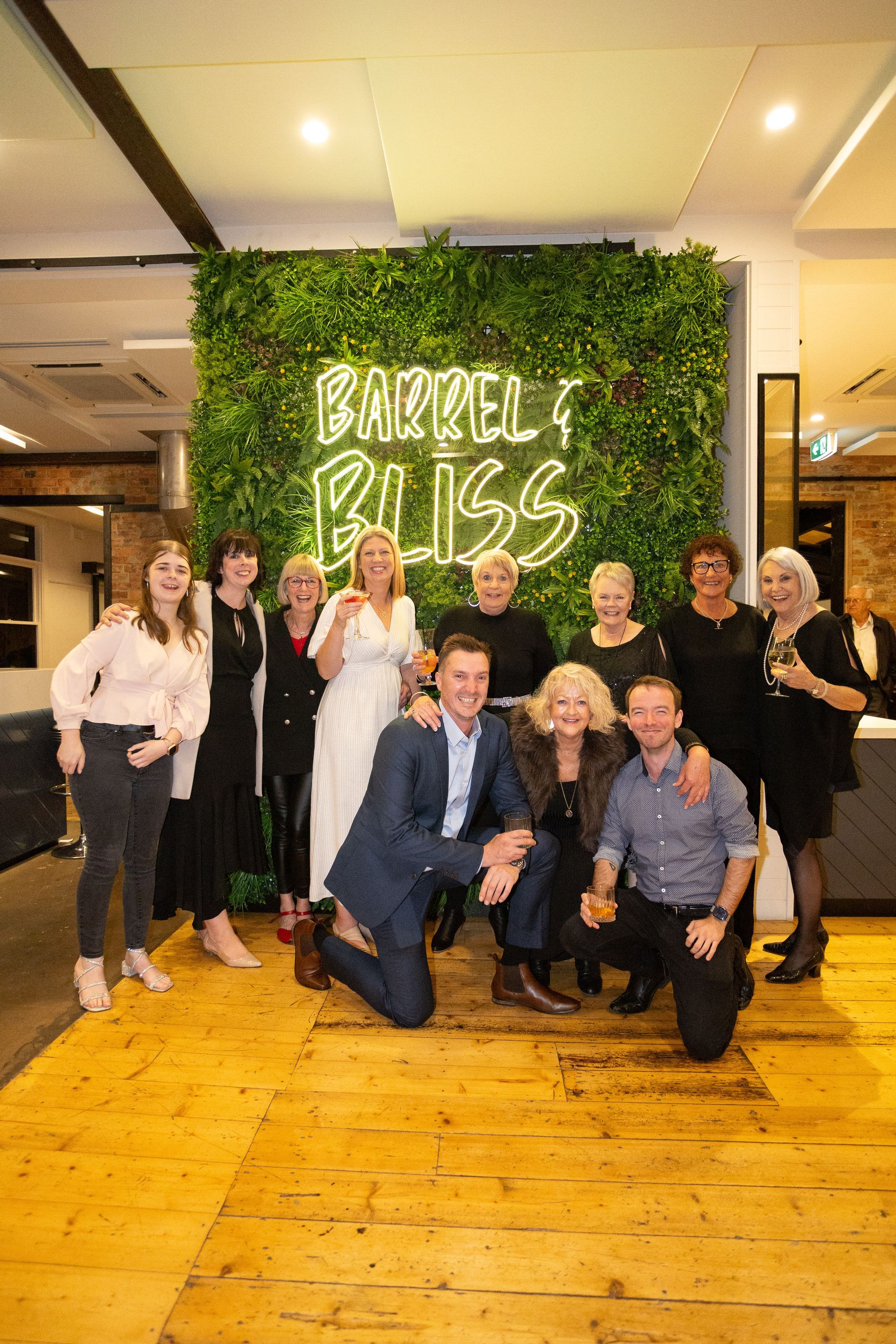 Group photo in front of a green wall with 