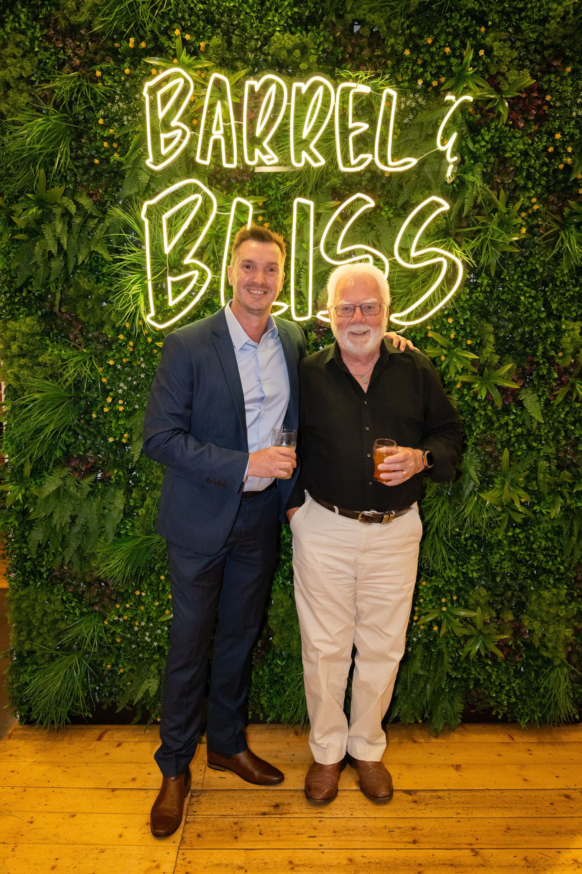 Two men pose in front of a 