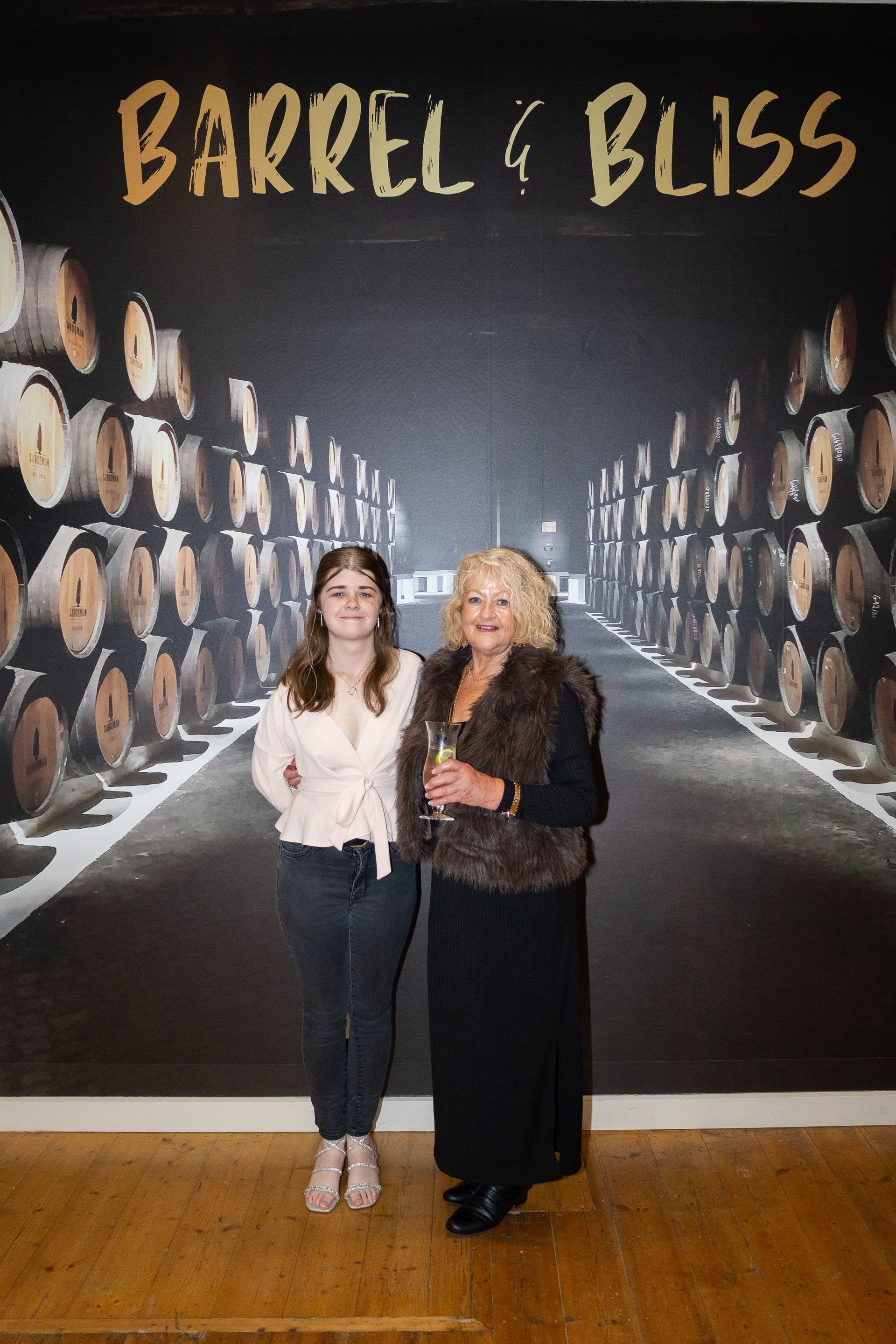 Two women pose in front of a 