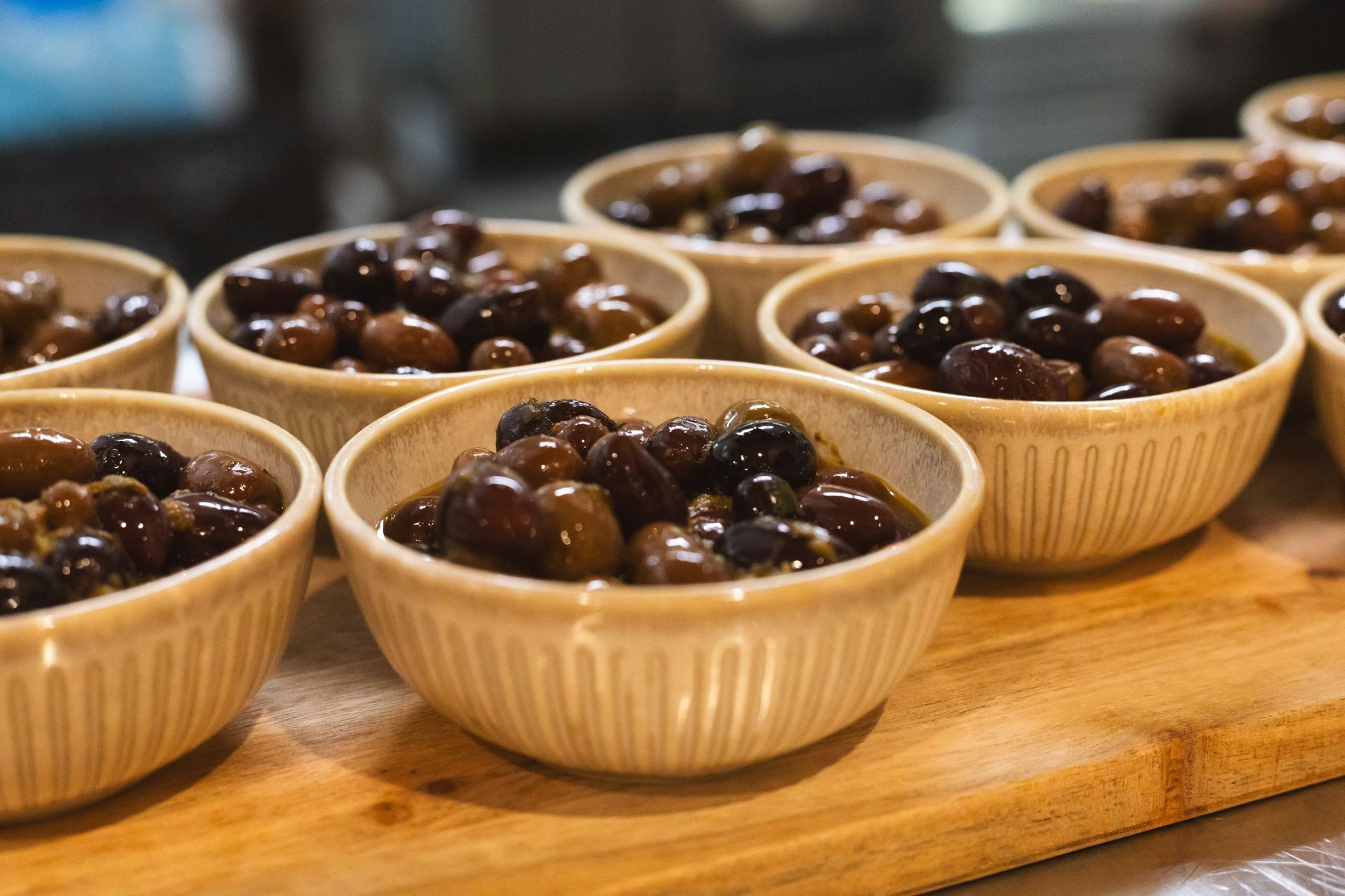 Bowls of dark olives on a wooden surface.