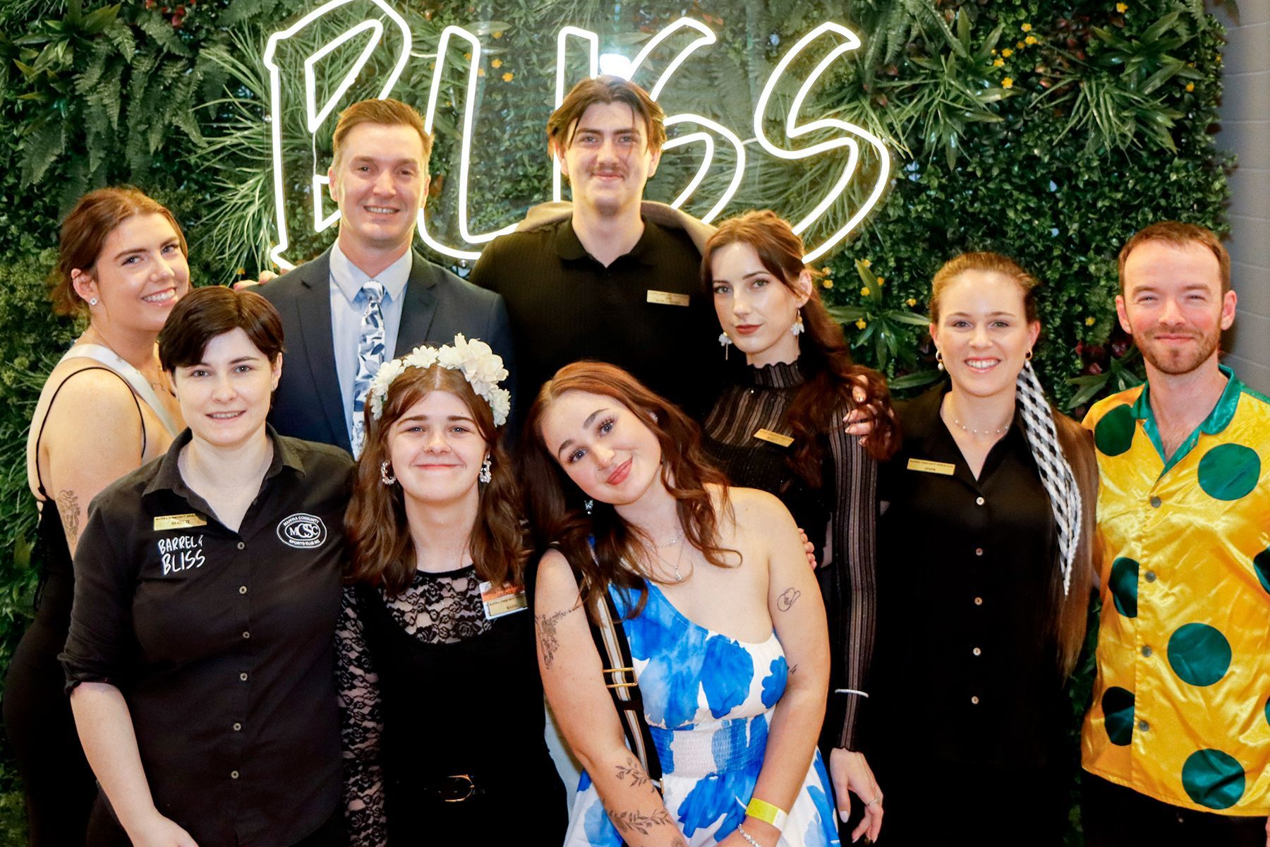 Group of people posing for a photo in front of a 