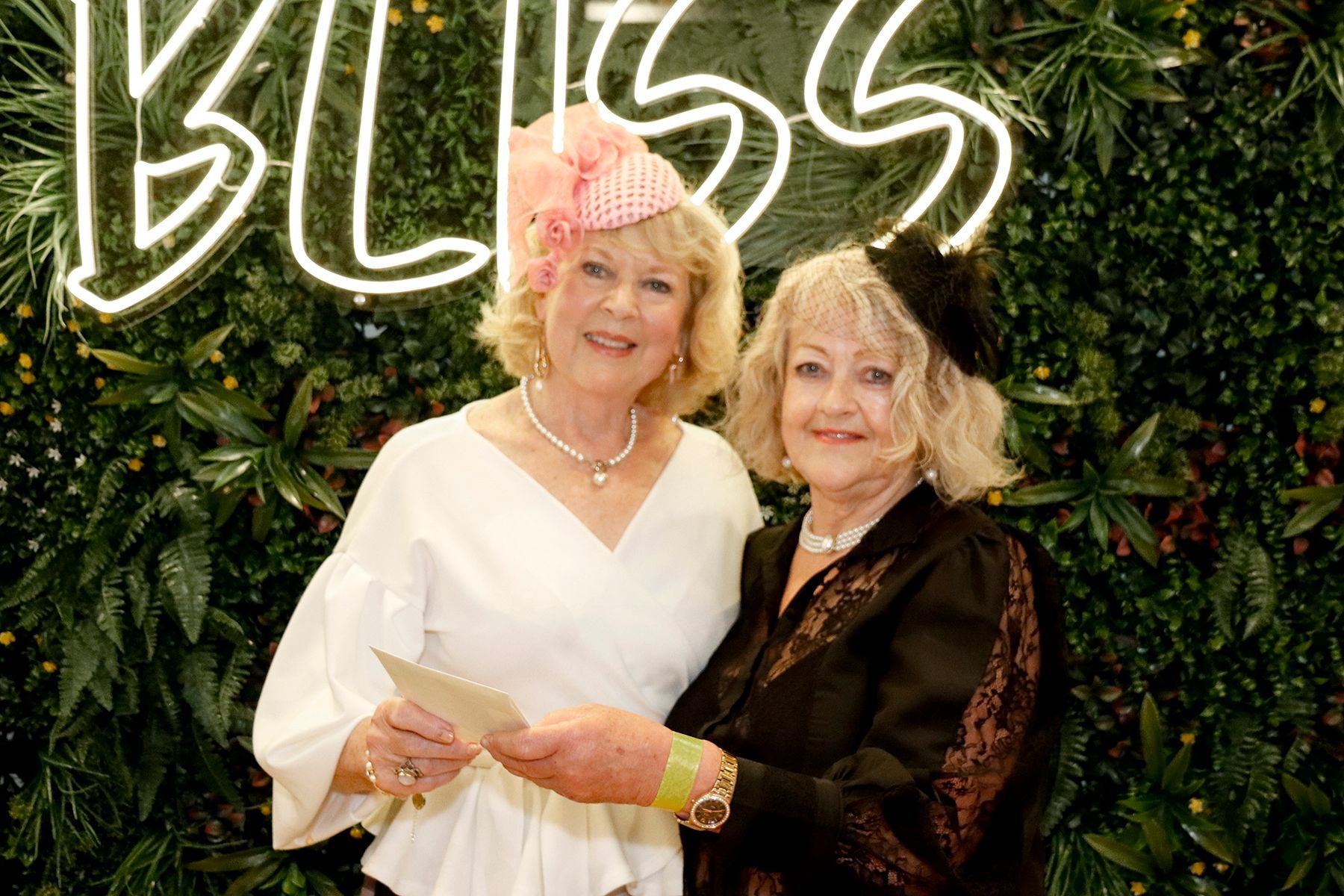 Two women smiling in front of a 