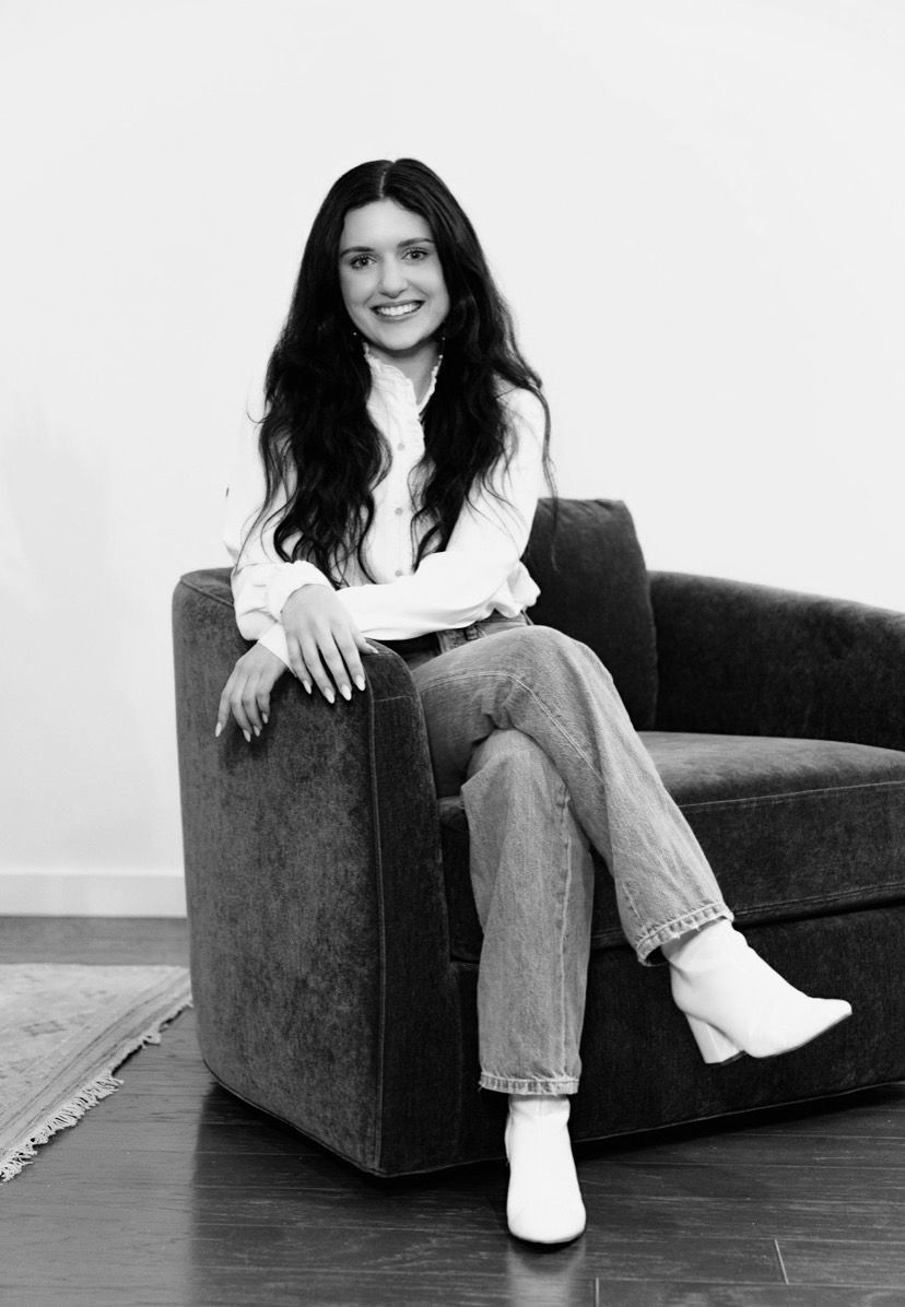 A black and white photo of a woman sitting in a chair.