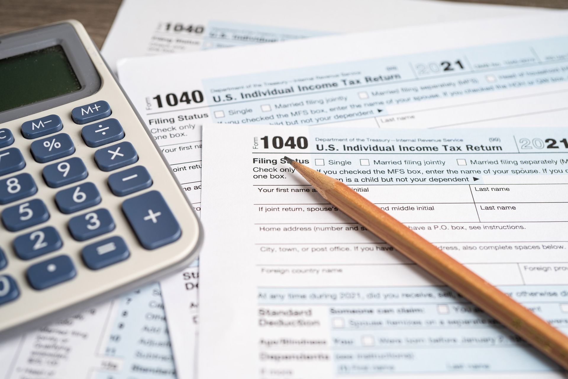 A calculator and pencil are sitting on top of a tax form.