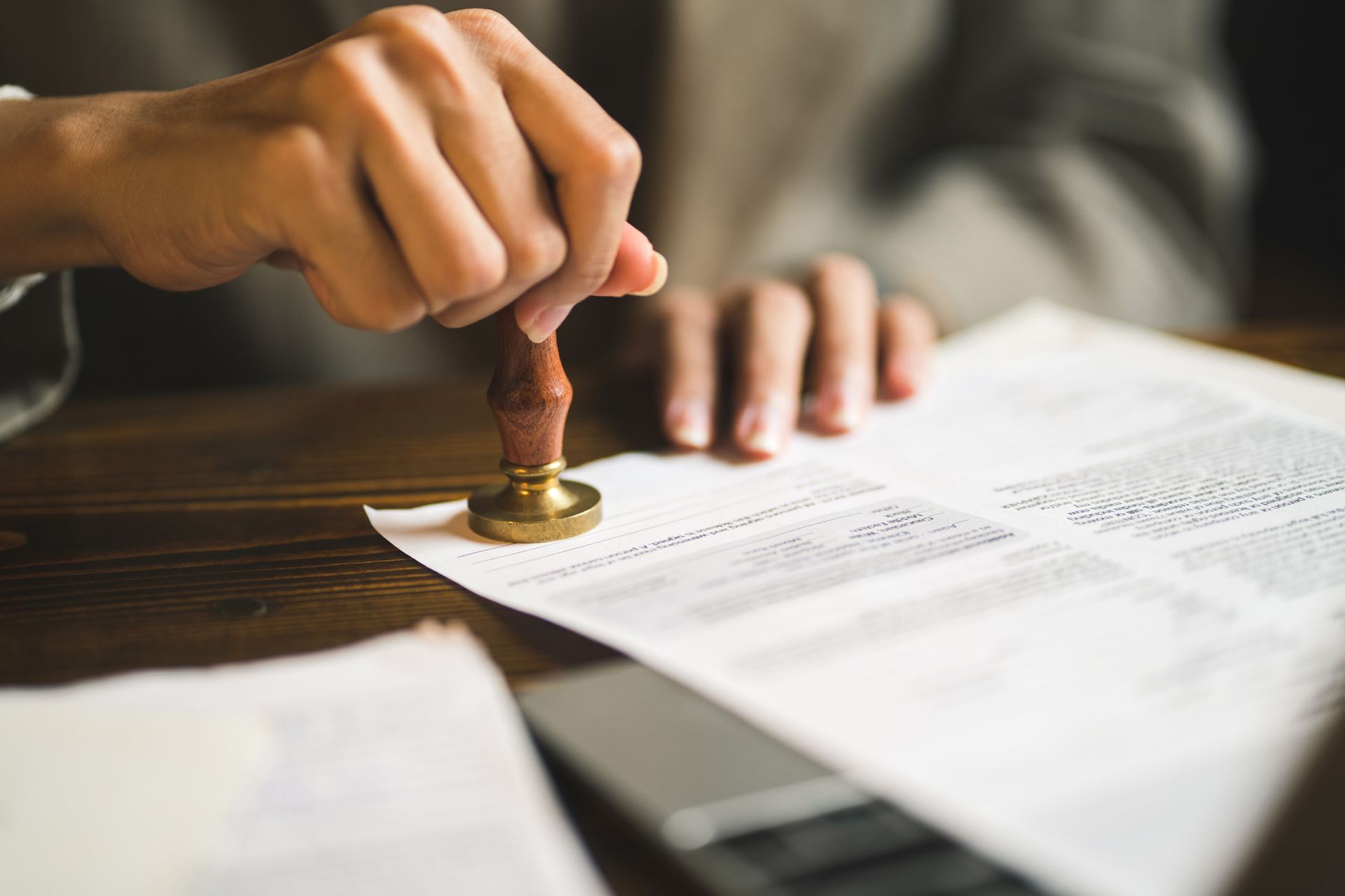 A person is stamping a document with a wax seal.