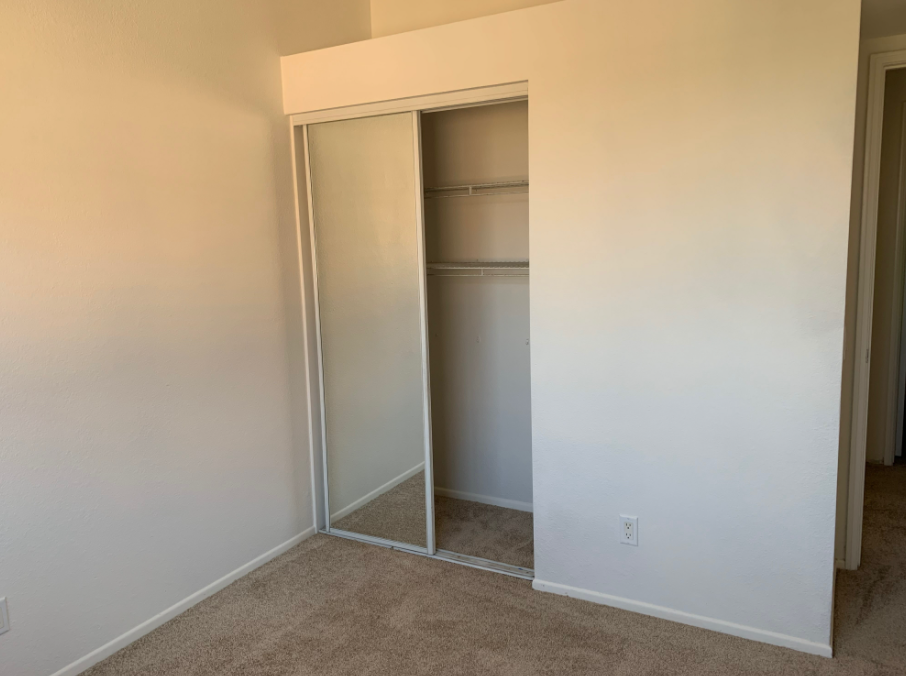 a bedroom with a sliding glass door closet .