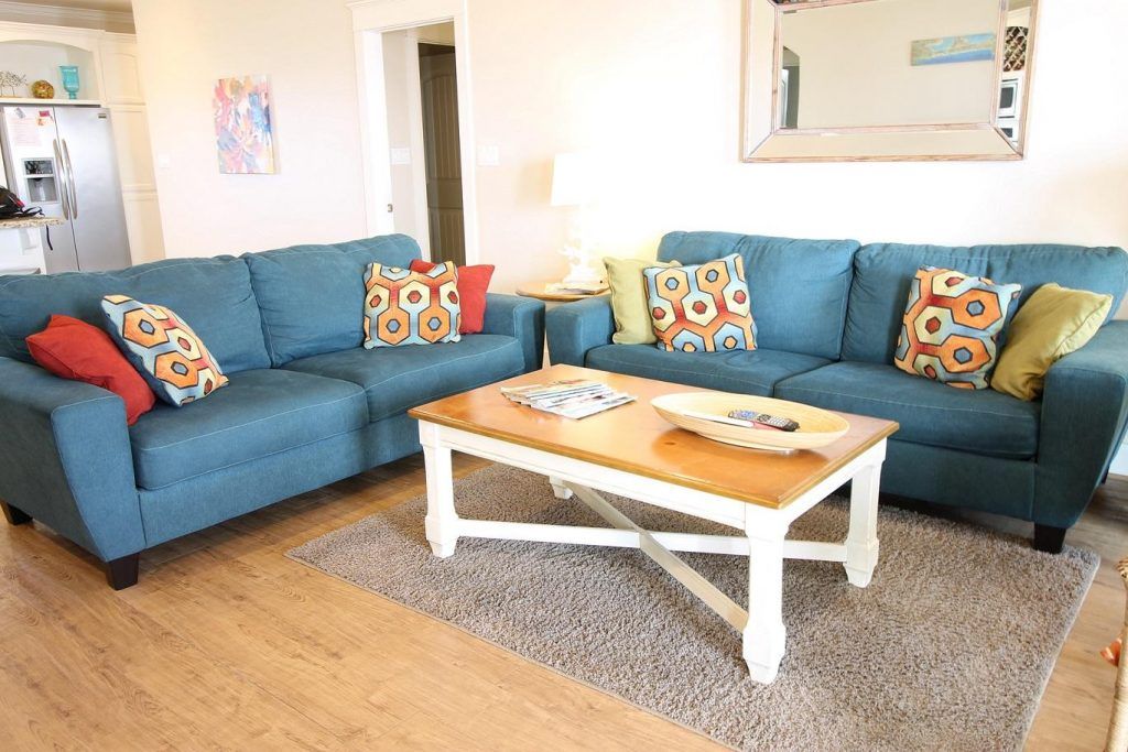 a living room with two blue couches and a coffee table