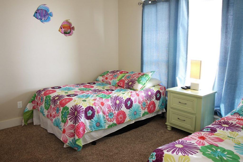 a bedroom with two beds , a nightstand , and a window .