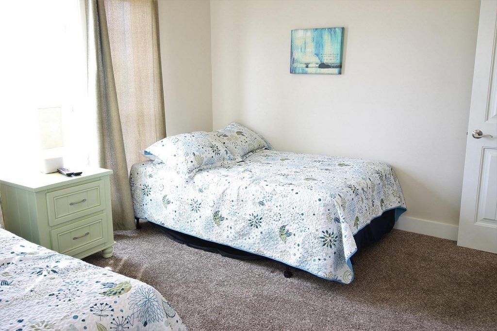 a bedroom with two beds and a nightstand .