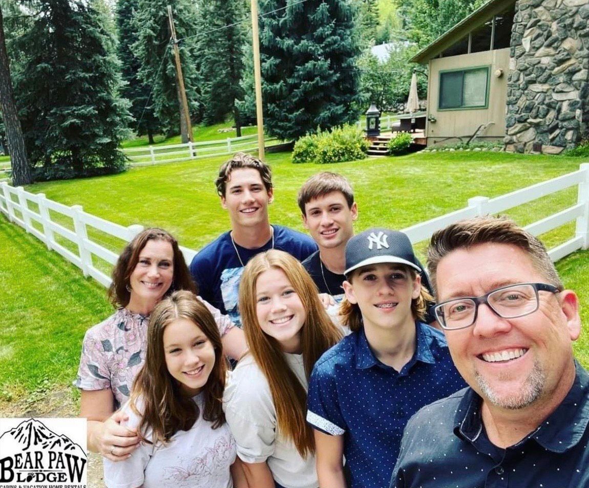a group of people are posing for a picture in front of a house .