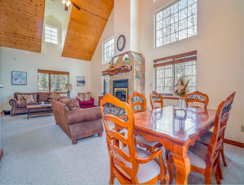 a living room with a table and chairs and a fireplace
