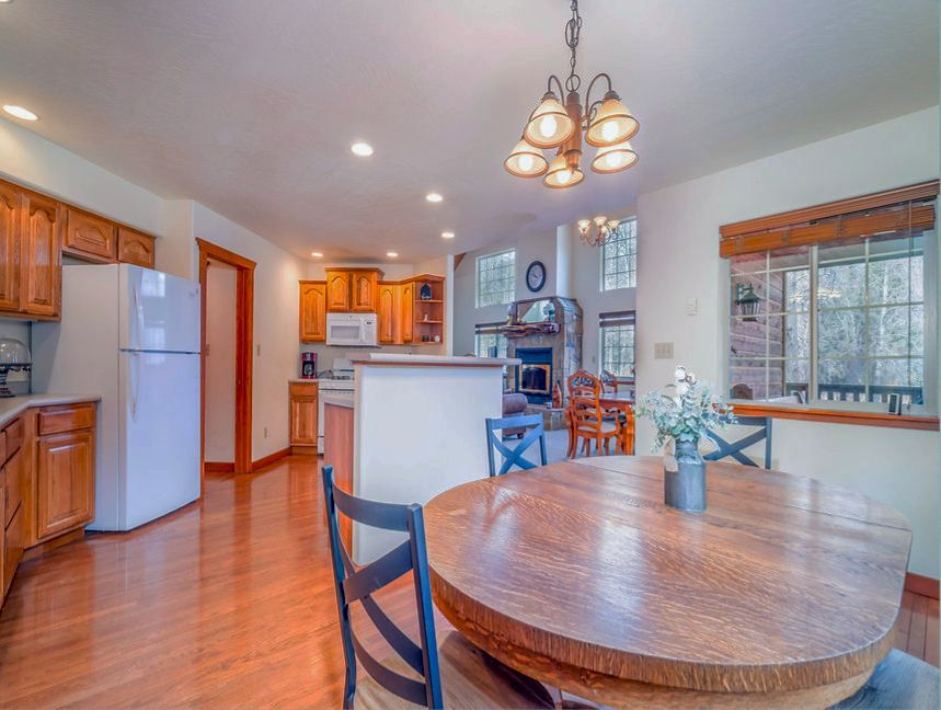 a kitchen with a table and chairs and a refrigerator .