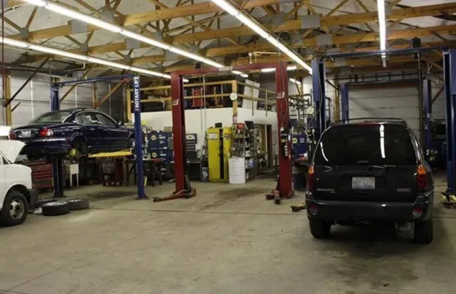 A car is sitting on a lift in a garage.