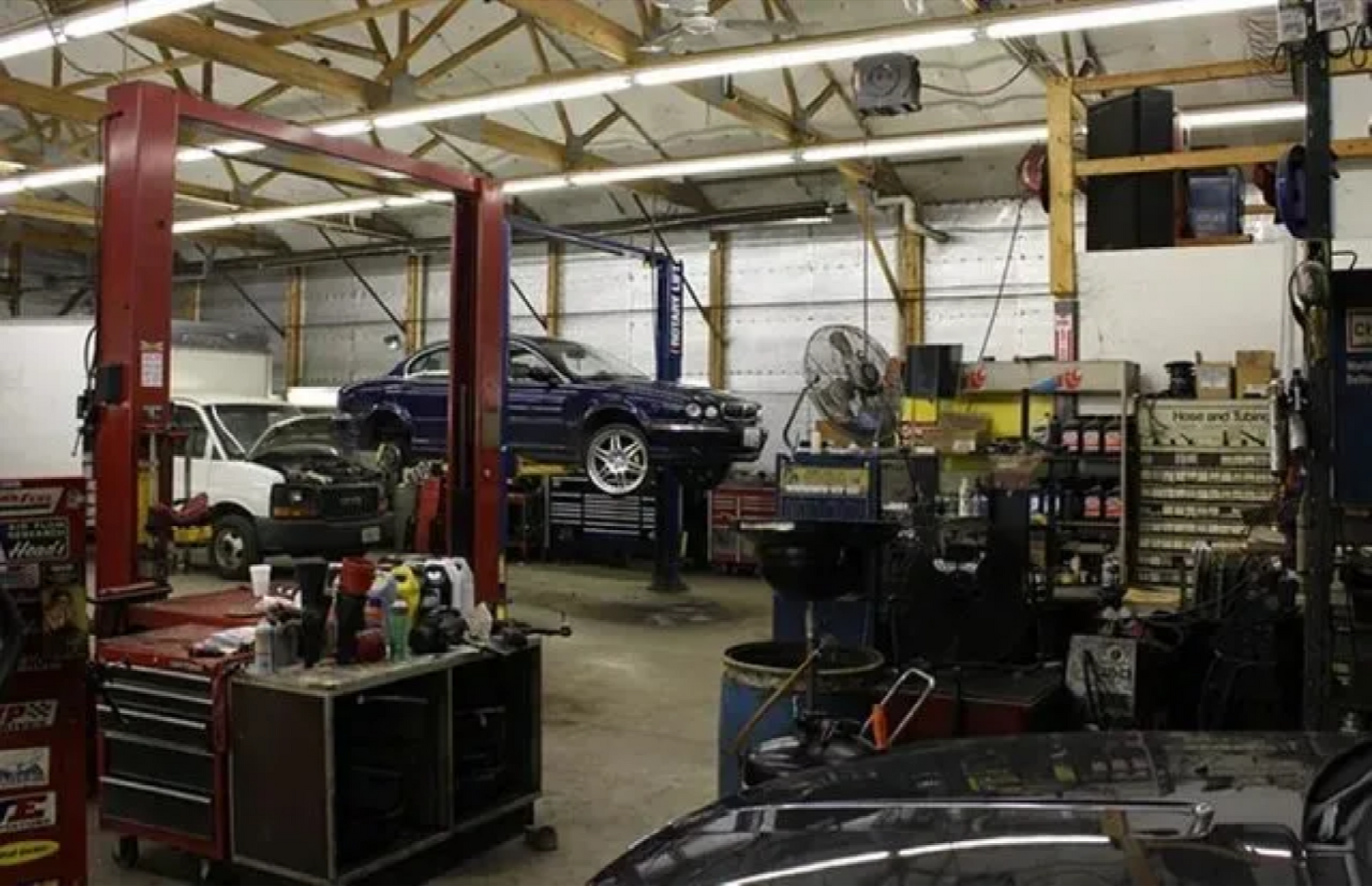A car is sitting on a lift in a garage.