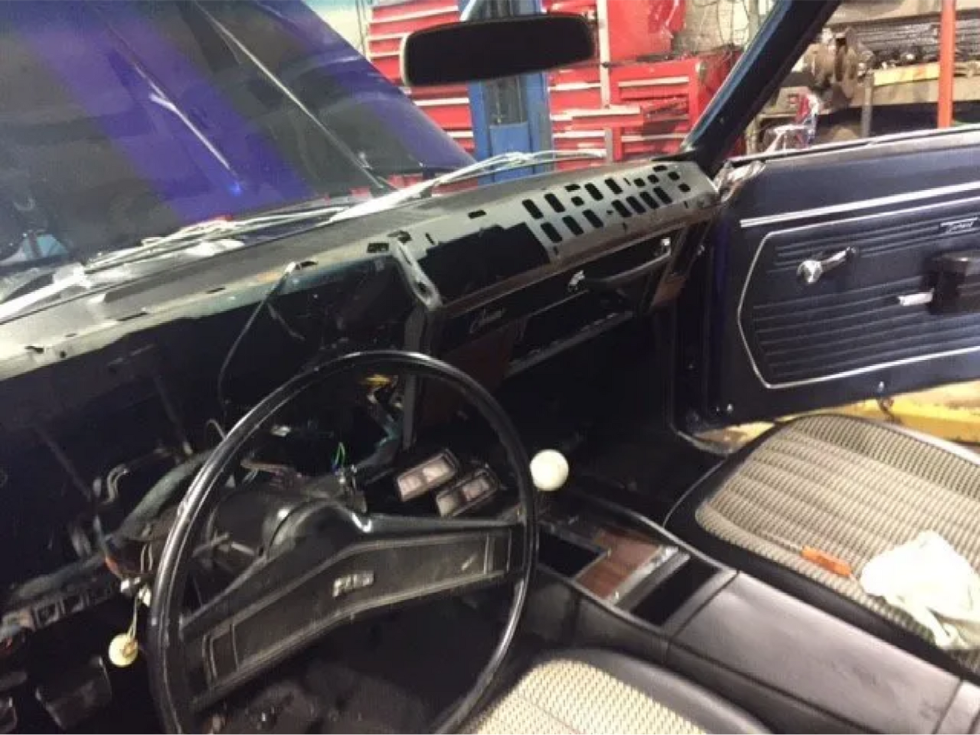 The interior of a car with the steering wheel removed