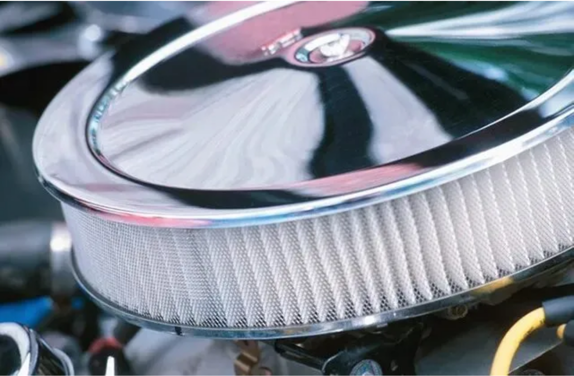 A close up of a chrome air filter on a car engine
