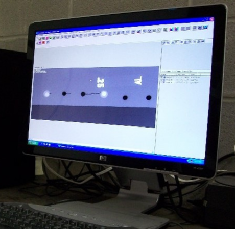 An HP computer monitor displaying a software interface with a graphical design featuring black and white dots on a bar.