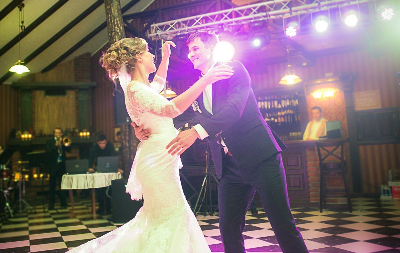 The bride and groom dance surrounded by movable lighting at their wedding reception