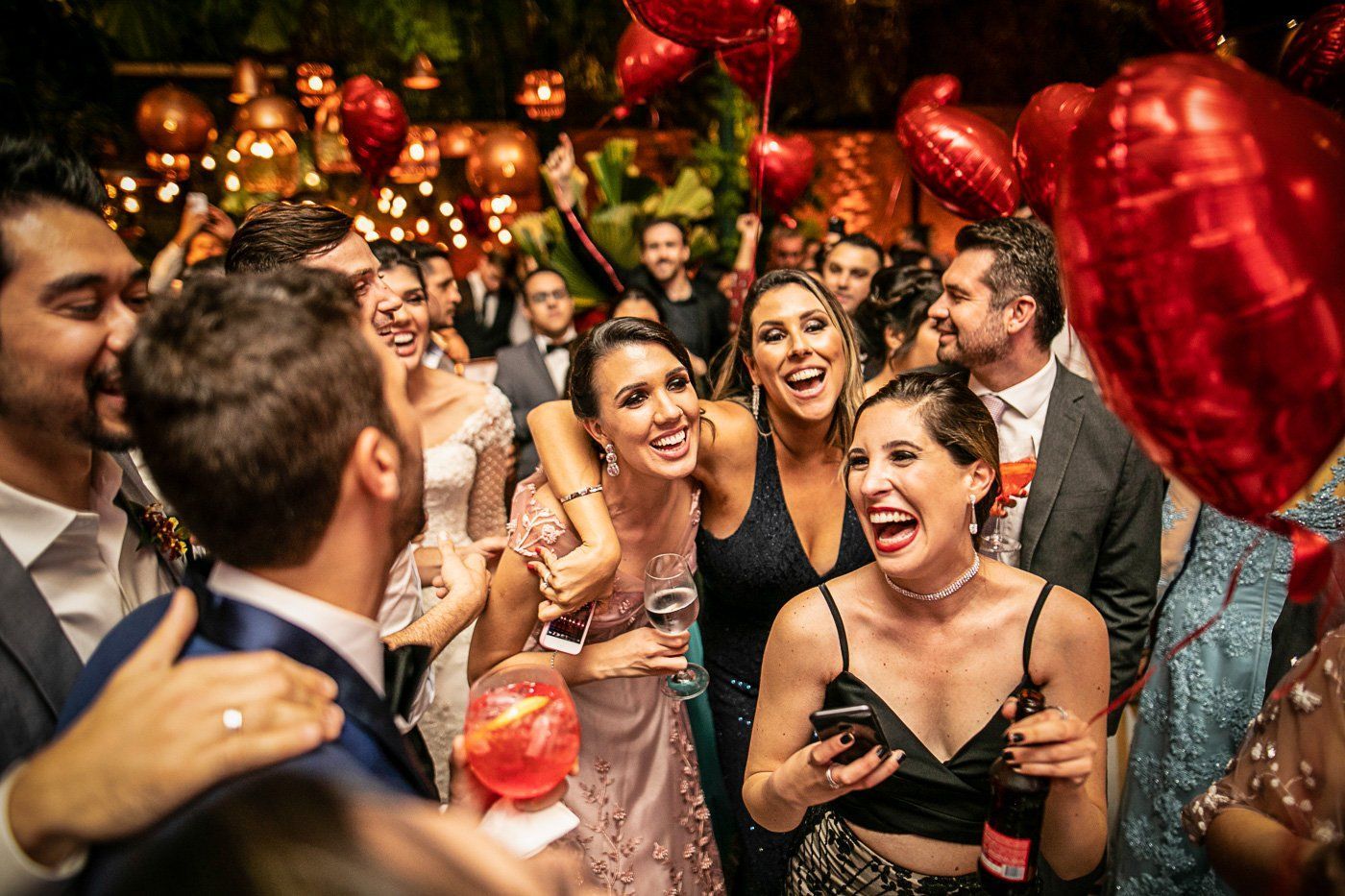 A large group of wedding guests laugh at a memorable reception. Aaron Bracken delivers personalized playlists.