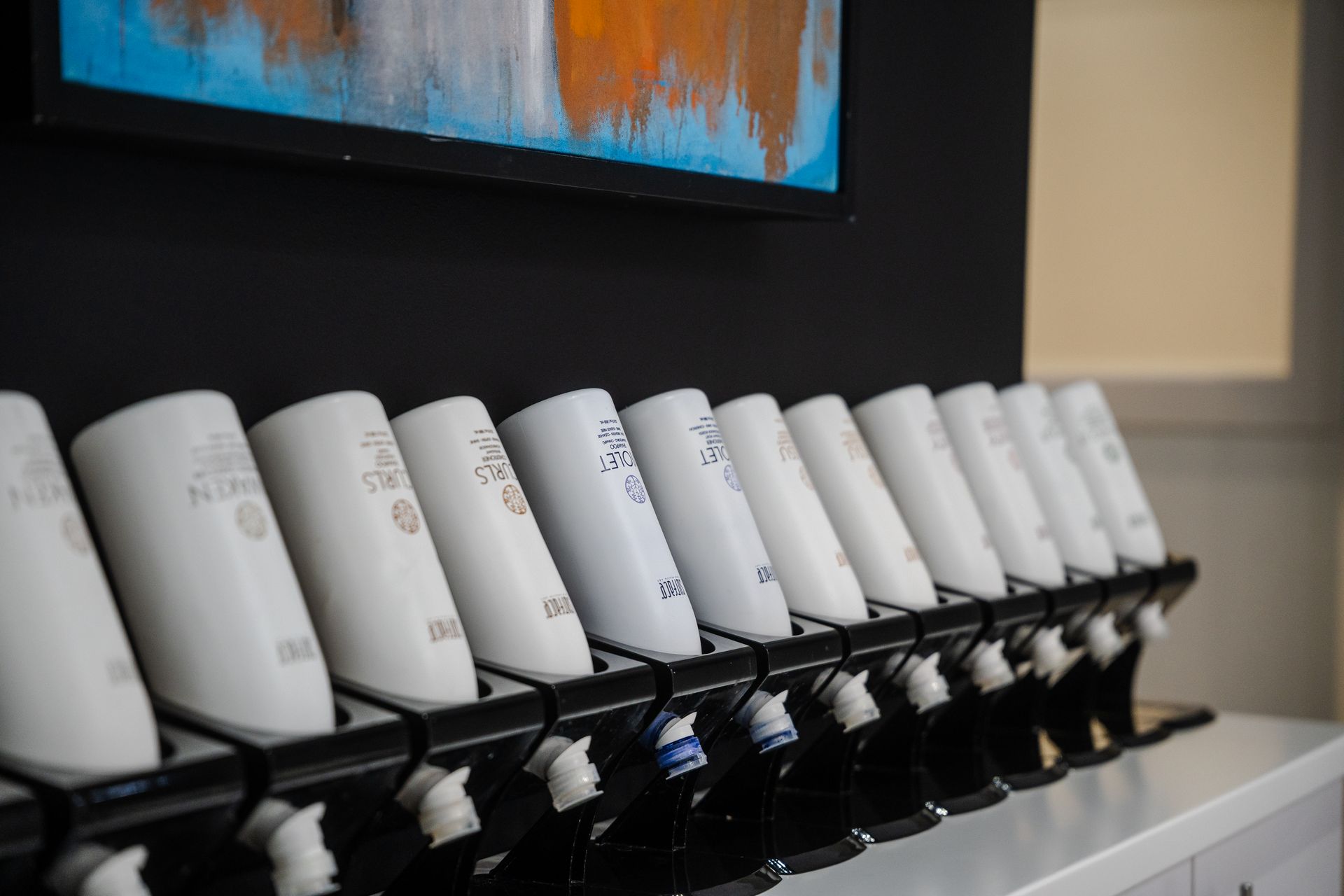 Two women are sitting at a table looking at a laptop computer.