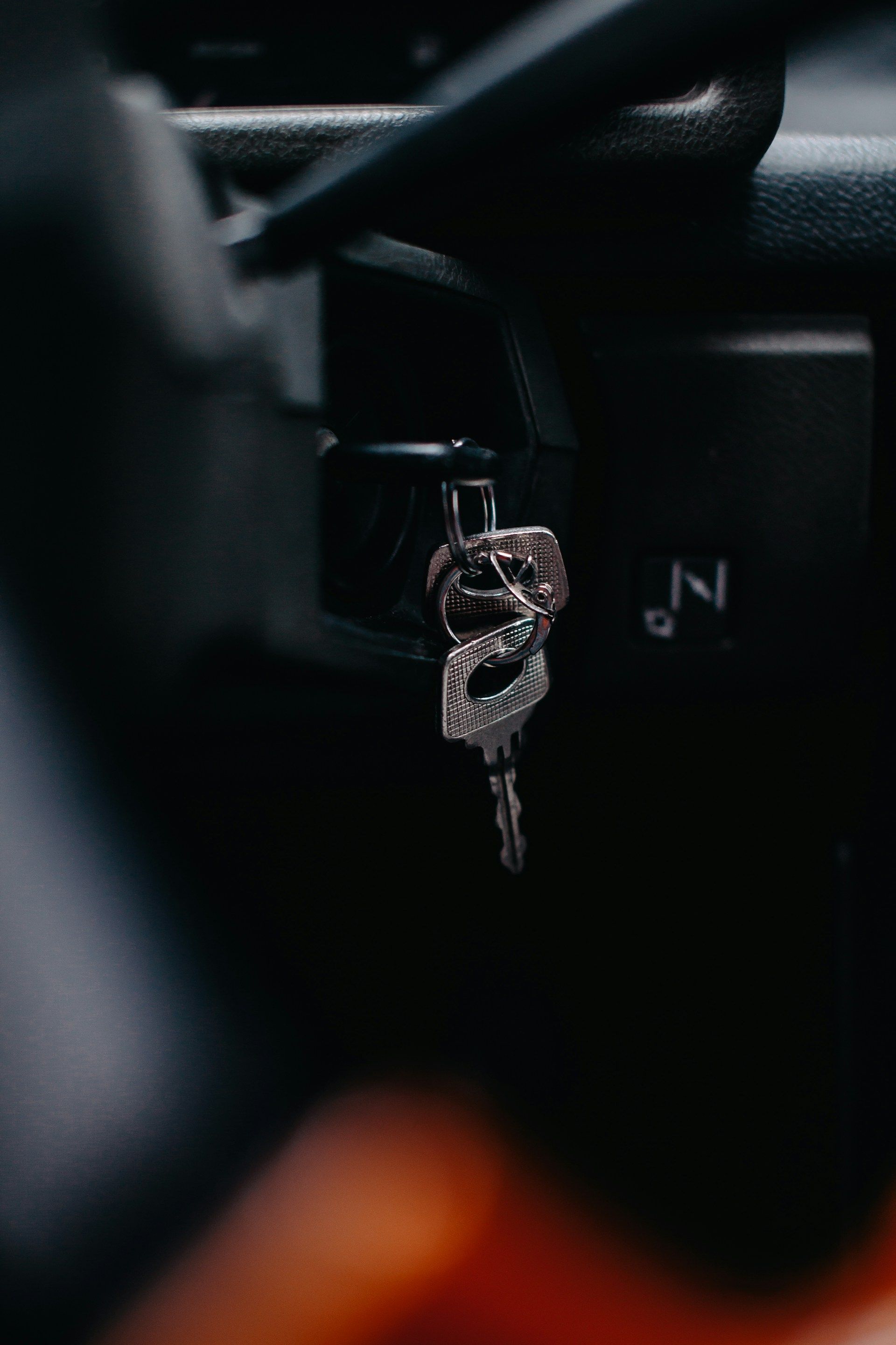 A car is driving down a road in the rear view mirror.