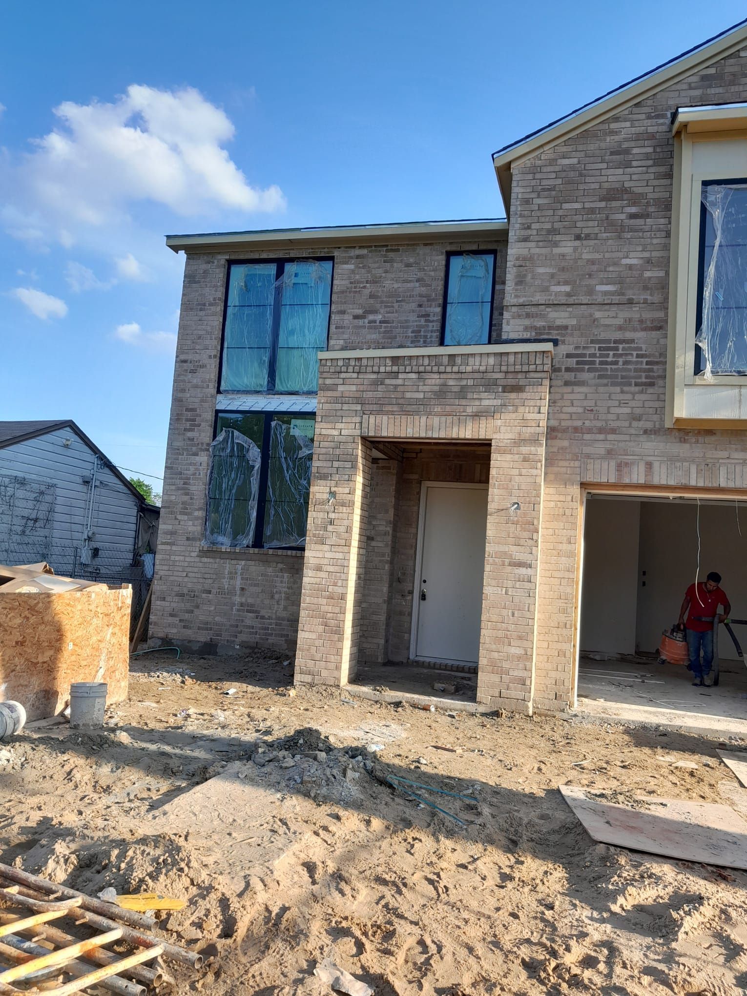 A large brick house is being built in a residential area.