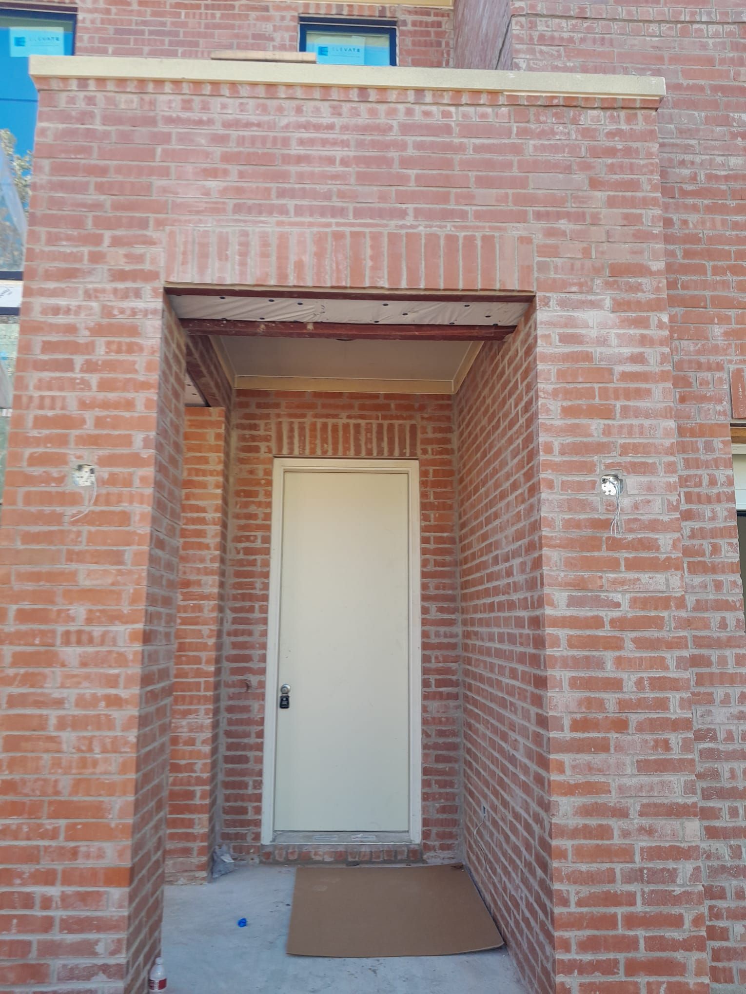 A brick building with a white door and a porch.