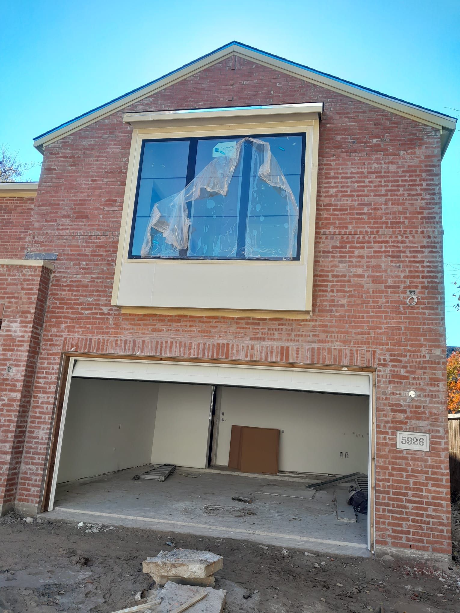 A brick building with a garage door and a large window.