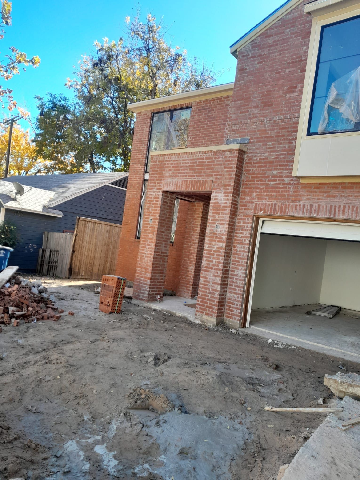 A brick house with a garage underneath it is being built.