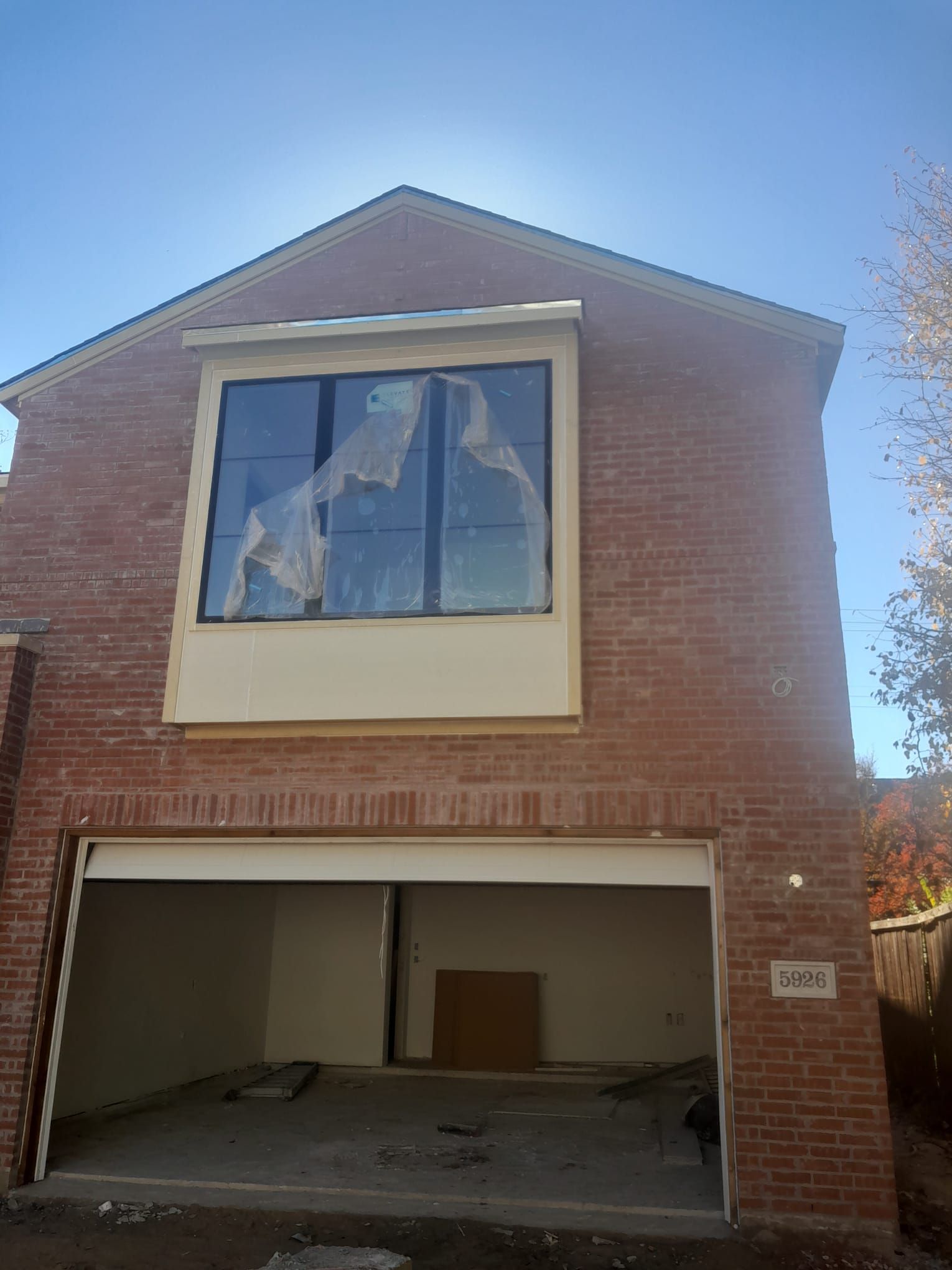 A brick house with a garage and a large window.