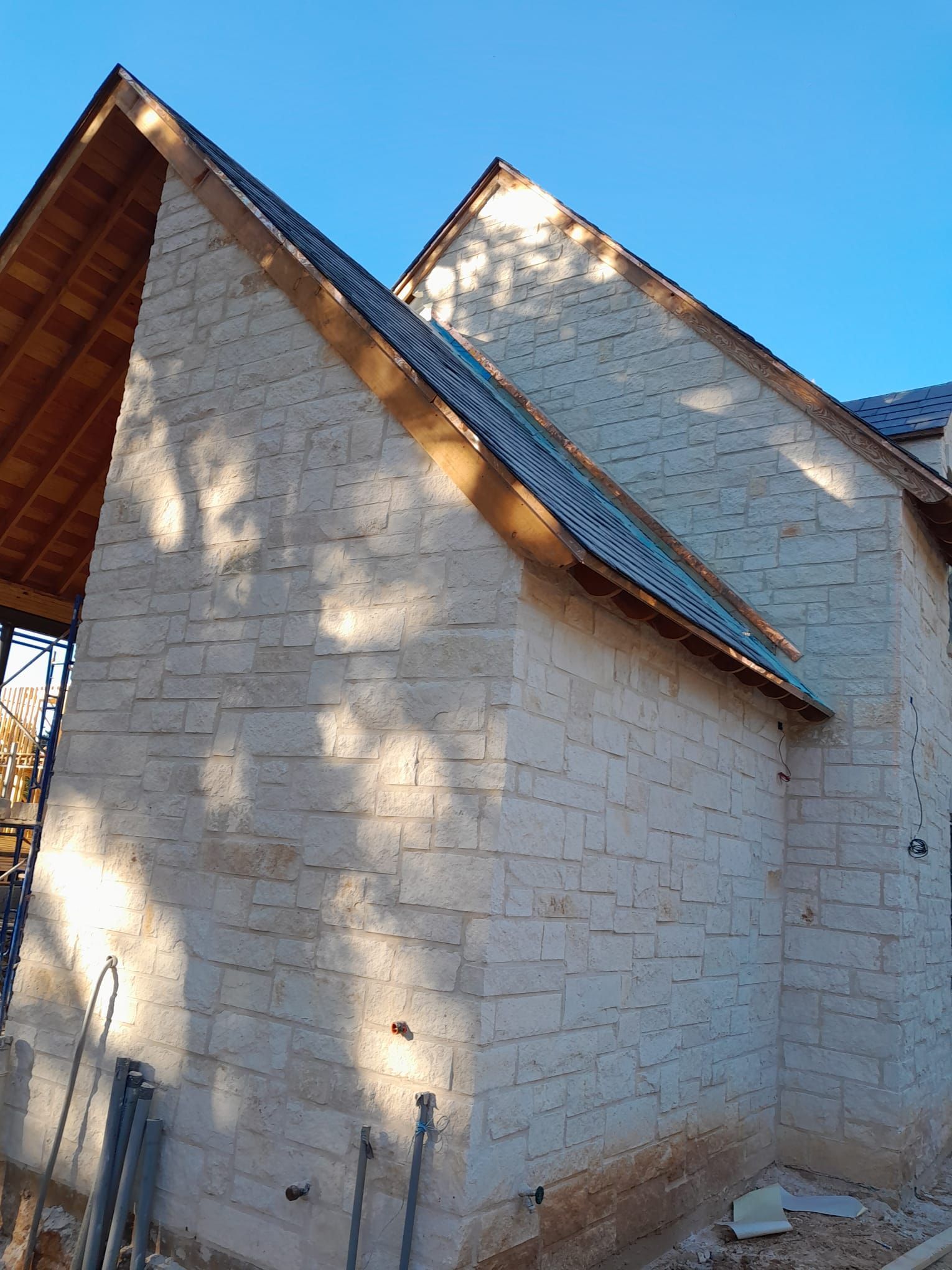 A white brick building with a wooden roof