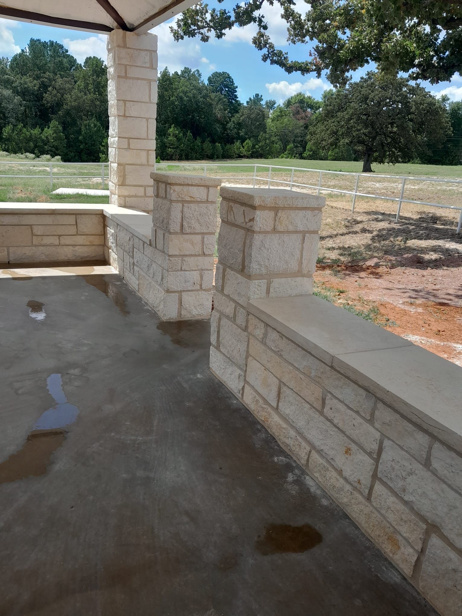 A stone wall with pillars in front of a cemetery
