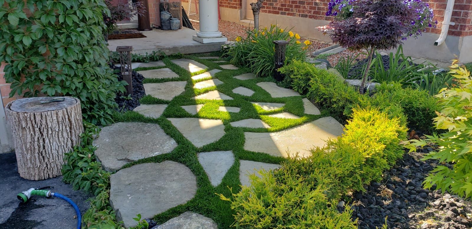 A stone walkway surrounded by plants and bushes in a garden.
