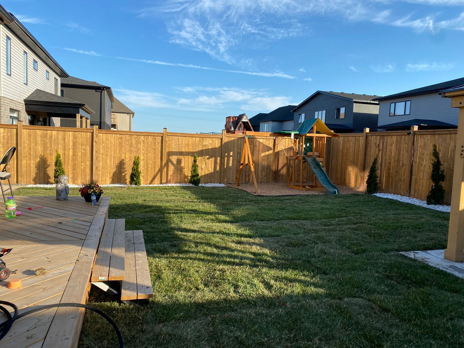 A backyard with a wooden fence and a playground.