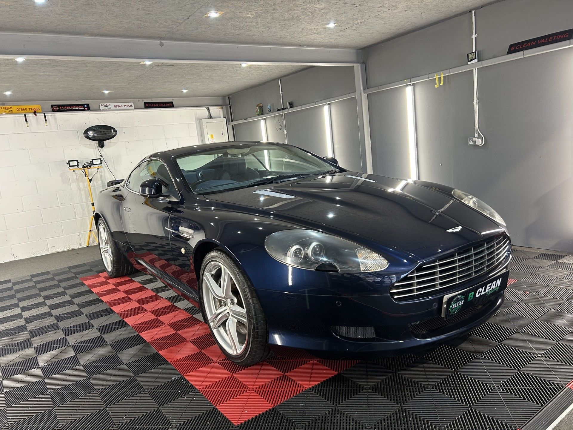 A blue sports car is parked in a garage.
