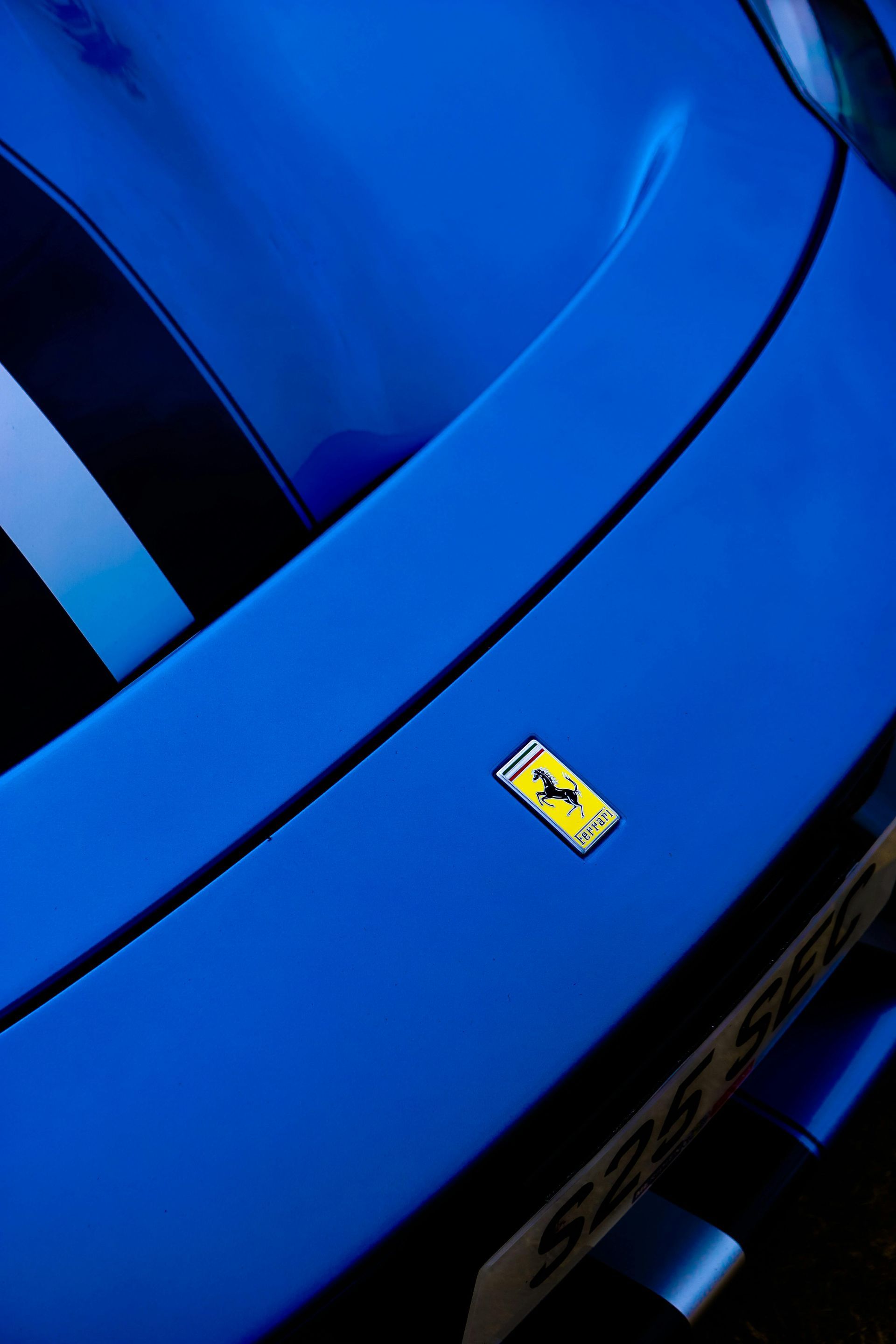 A close up of a blue car with a yellow ferrari logo