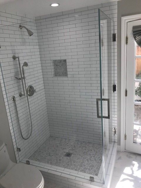 A bathroom with a walk in shower and a toilet.