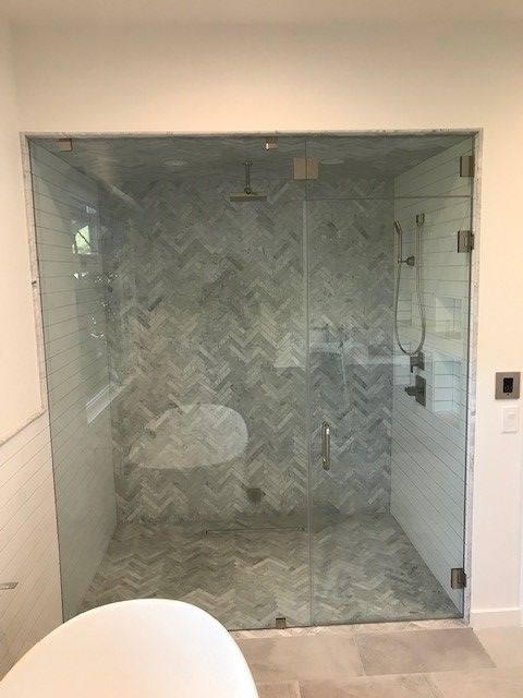 A bathroom with a walk in shower and a bathtub.