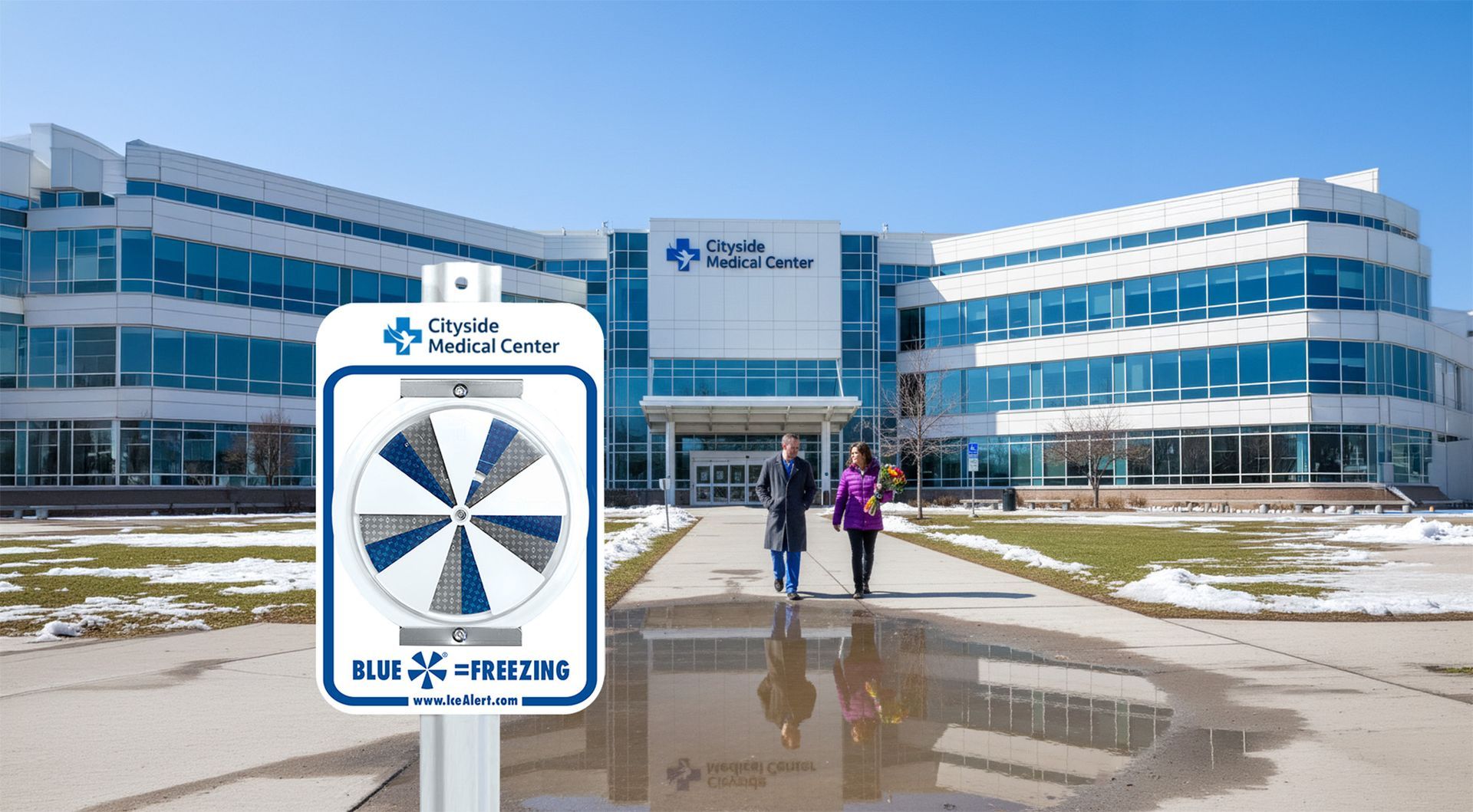 IceAlert safety Sign in front of a medical center. Two people walk towards the entrance. Icy winter conditions