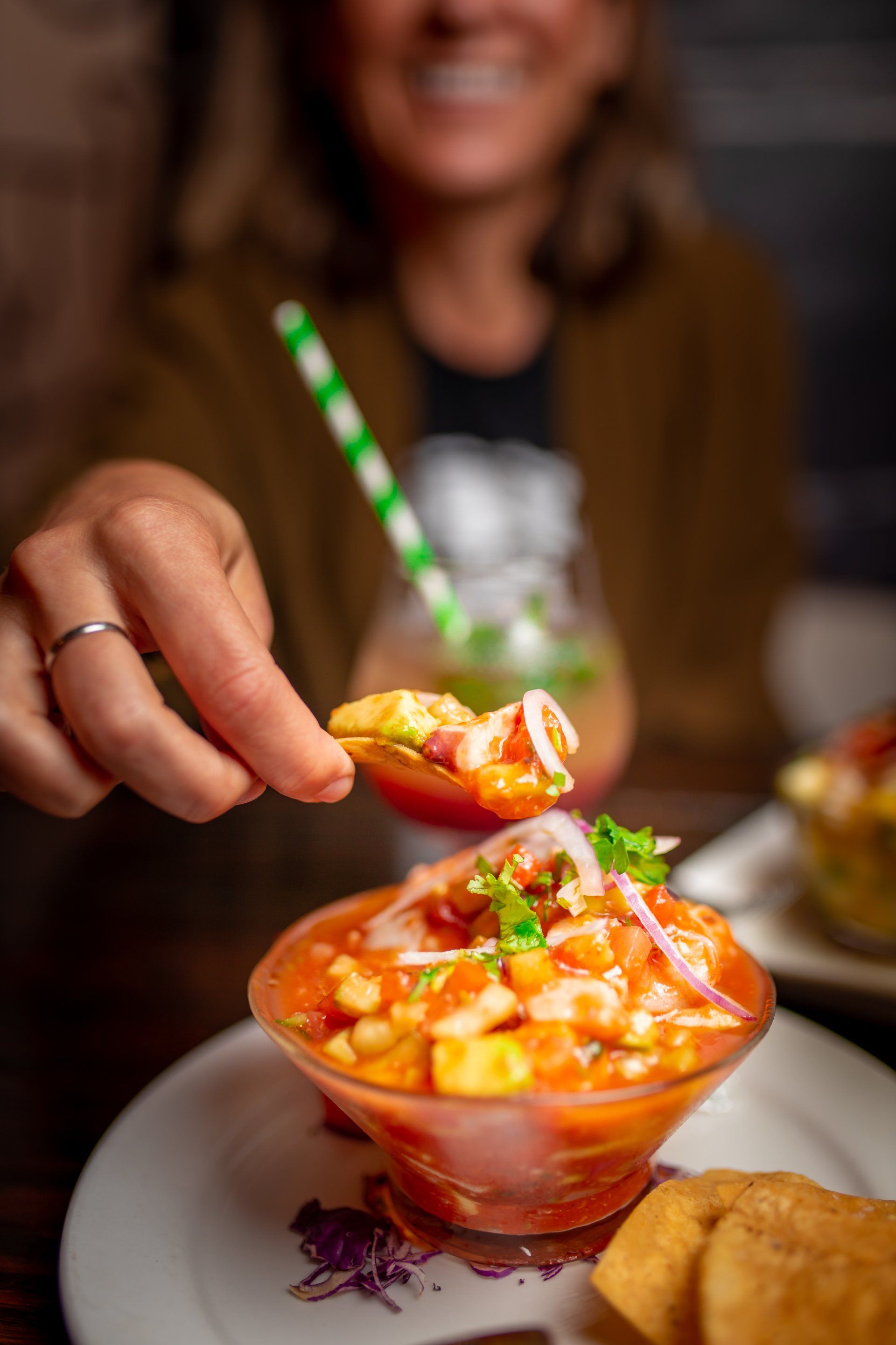 hand dipping into ceviche